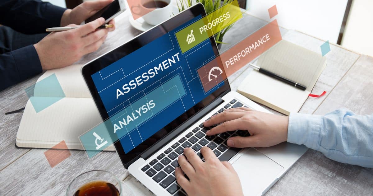 Person working on laptop. On the screen is assessment, analysis, progress.