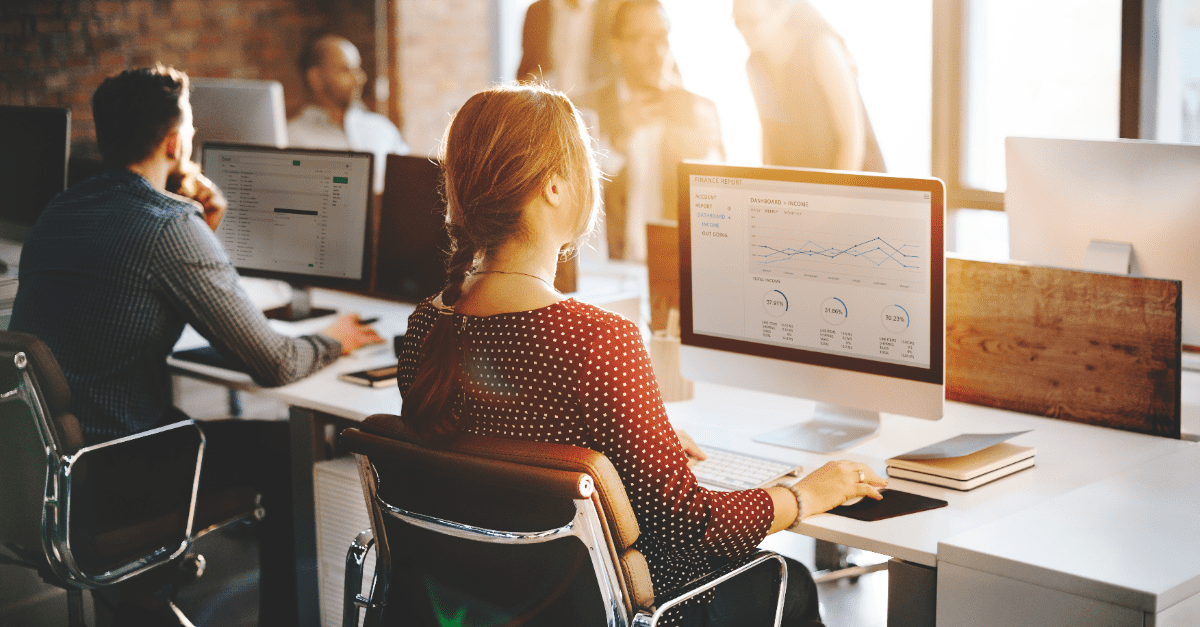Office workers sitting at desks, analyzing reports that represent data bias.